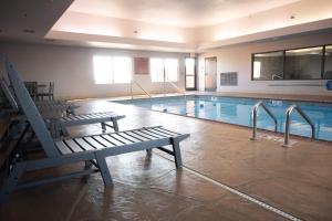 a swimming pool with two benches in a building at Buffalo Run Casino & Resort in Miami