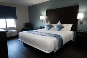 a hotel room with a large bed with blue pillows at Buffalo Run Casino & Resort in Miami