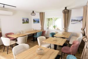 a restaurant with wooden tables and chairs and windows at Apartmenthotel Rosentaler Hof Quartier2 in Pirk