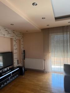 a living room with a flat screen tv next to a window at Prishtina Luxury House in Laplje Selo