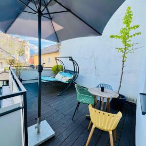 a patio with a table and chairs and an umbrella at Boutique Hotel Goldenes Lamm Villach in Villach