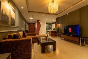 a living room with a couch and a tv at Gold Crest Signature Boutique Apartments With City Views -DHA PHASE 4 LAHORE in Lahore