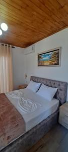 a large bed in a bedroom with a wooden ceiling at Vila Nakaj Guest House in Gjirokastër