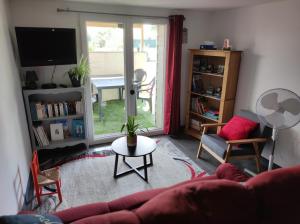 a living room with a couch and a table at "La maison fleurie" Sud Vendée 85 in Avrillé