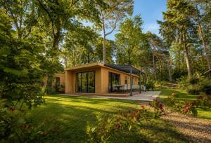 a house in the woods with a garden at Vakantiepark Samoza in Vierhouten