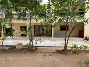 a house with two trees in front of it at Samba immo chez Mbaye in Fatick +3 photos