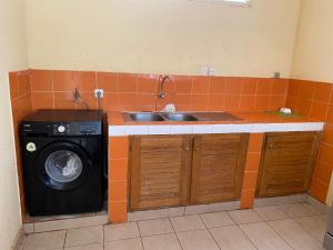 a kitchen with a sink and a washing machine at Samba immo chez Mbaye in Fatick