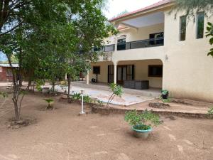 a large white building with trees in front of it at Samba immo chez Mbaye in Fatick