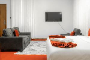 a hotel room with a bed and two chairs and a tv at GRANADA HOTEL NAIROBi in Nairobi