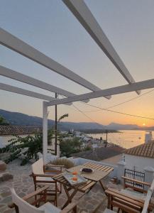 a patio with a table and chairs and a view at Panoramic View apartment in Poros