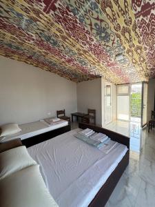 a bedroom with a large bed with a colorful ceiling at Гостевой дом Sartepo in Samarkand +79 photos