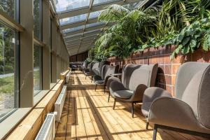 a row of chairs in a building with plants at Scandic Rosendahl in Tampere
