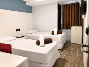 a room with three beds with towels on them at Caruaru Pallace Hotel in Caruaru +10 photos