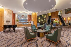 a hotel lobby with chairs and a piano at Sandton Sun and Towers in Johannesburg