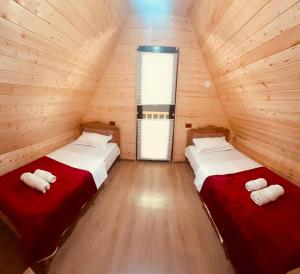 two beds in a room with wooden walls at Pine House Borjomi , Mountain View in Borjomi