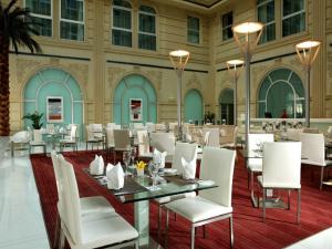 a restaurant with white chairs and tables in a building at Villa Rotana in Dubai