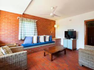 a living room with a blue couch and a tv at 8 Hewitt @ Tiffany's in Sheffield Beach