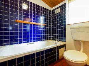 a blue tiled bathroom with a toilet and a tub at 8 Hewitt @ Tiffany's in Sheffield Beach +34 photos