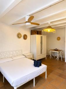a bedroom with a white bed and a ceiling fan at Villa Mediterraneo Rooms Piscina jardin parking in Blanes
