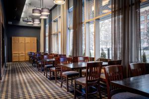 a dining room with tables and chairs and windows at Scandic Tampere Hämeenpuisto in Tampere