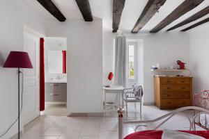a bedroom with white walls and a table and chairs at Logis des gourmets in Hommes