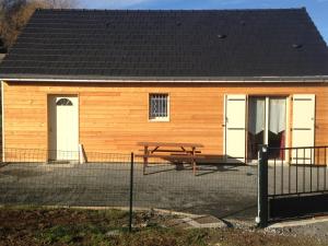 a building with a picnic table in front of it at Le chalet des Patures route des Rocs in Rochefort-Montagne