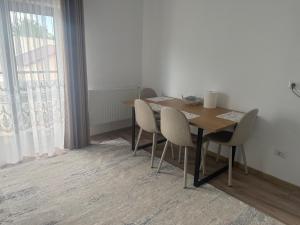 a dining room with a table and chairs and a window at Eli house in Târgu Neamț