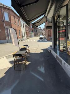 a group of tables and chairs sitting outside of a store at 1 Grande Chambre Frigo privé in Charleroi
