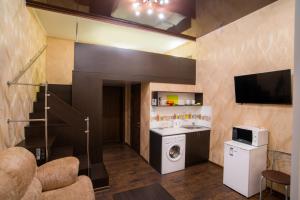 a kitchen with a stove, oven, microwave and cabinets at Soprano Apart Hotel in Odesa