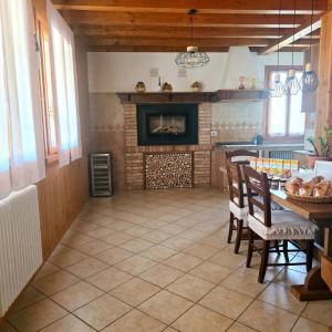 a living room with a fireplace and a table and chairs at Locanda Livenza camere in Motta di Livenza
