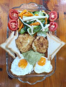a plate of food with eggs and bread and vegetables at Haven Kitchen & Cafe in Nguyễn Thôn +40 photos