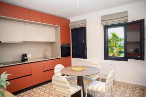 a kitchen with orange cabinets and a table and chairs at Aellia Bay Residences in Alinda