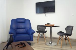 a blue chair and two chairs and a table at Panorama Motel -Wellness in Veľký Meder