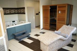 a bathroom with a tub and a chair and a couch at Panorama Motel -Wellness in Veľký Meder +39 photos