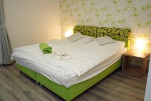 a bedroom with a bed with a green headboard at Panorama Motel -Wellness in Veľký Meder