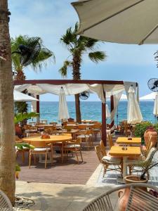a restaurant with tables and chairs and the ocean at Be Batroun in Batroûn