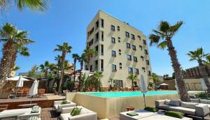a hotel with a swimming pool and palm trees at Be Batroun in Batroûn
