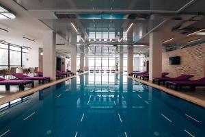 a swimming pool with purple chairs in a building at Kasimir Hotel & SPA in Bukovel