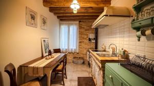 a kitchen with a wooden table and a sink at B&b ANTICO MAGLIO in Asolo