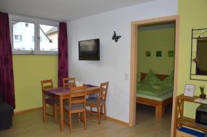 comedor con mesa, sillas y sofá en Ferienwohnung Am Brunnen (Nähe Europapark), en Rheinhausen