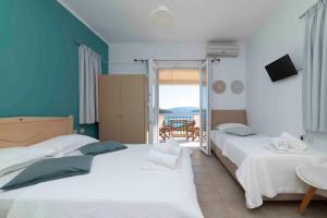 two beds in a room with a view of the ocean at San Lazzaro in Nydri