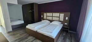 a small bedroom with a bed with white sheets at Apartment Hotel Citylight in Cologne