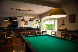 a pool table in a room with a bar at Dom Ravello in Telêmaco Borba