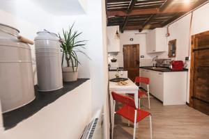 uma cozinha com cadeiras vermelhas, uma mesa e um balcão em Casa Sant'Agostino CITRA LT-2407 em Gênova