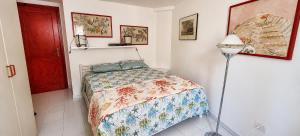 a small bedroom with a bed and a lamp at La Tonnara House in Stintino