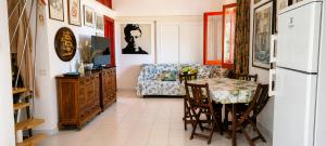 a dining room with a table and a refrigerator at La Tonnara House in Stintino