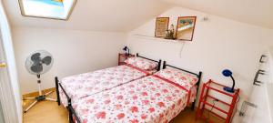 a bedroom with a bed and a fan at La Tonnara House in Stintino