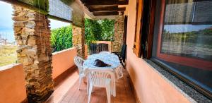 a table and chairs on a porch with a cat sitting on it at La Tonnara House in Stintino