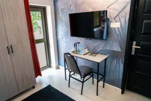a small table with a chair and a television on a wall at Explorers Hub in Kampala