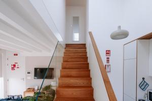 a staircase in a home with white walls and wooden floors at The Charming Loft in Esposende